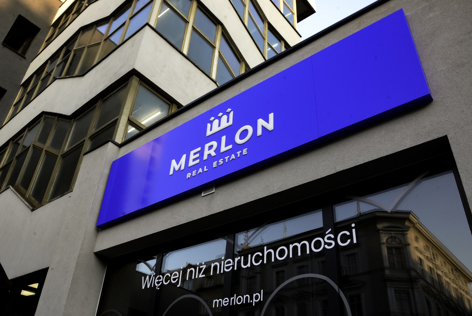 Szyld Merlon Real Estate na budynku biura
